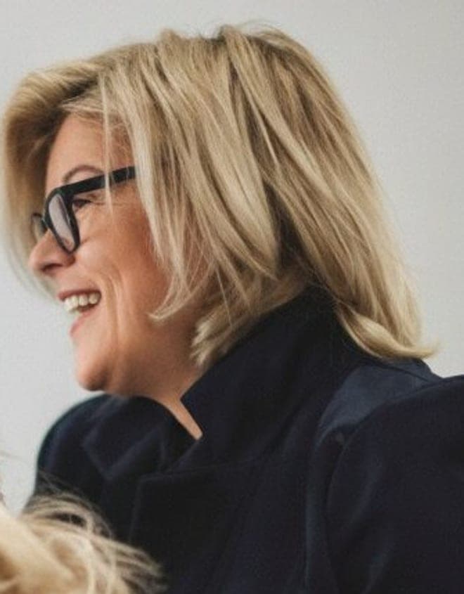 Michaela Gruber im Profil, während sie an einer Kundin arbeitet